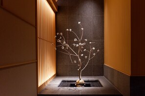 A minimalist indoor garden with a water feature, wooden paneling, and dark stone tiles. - THE GENERAL KYOTO Bukkoji Shinmachi (Kyoto)