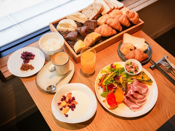 A breakfast buffet with various breads, pastries, a salad, and a fruit bowl. - THE GENERAL KYOTO Bukkoji Shinmachi (Kyoto)