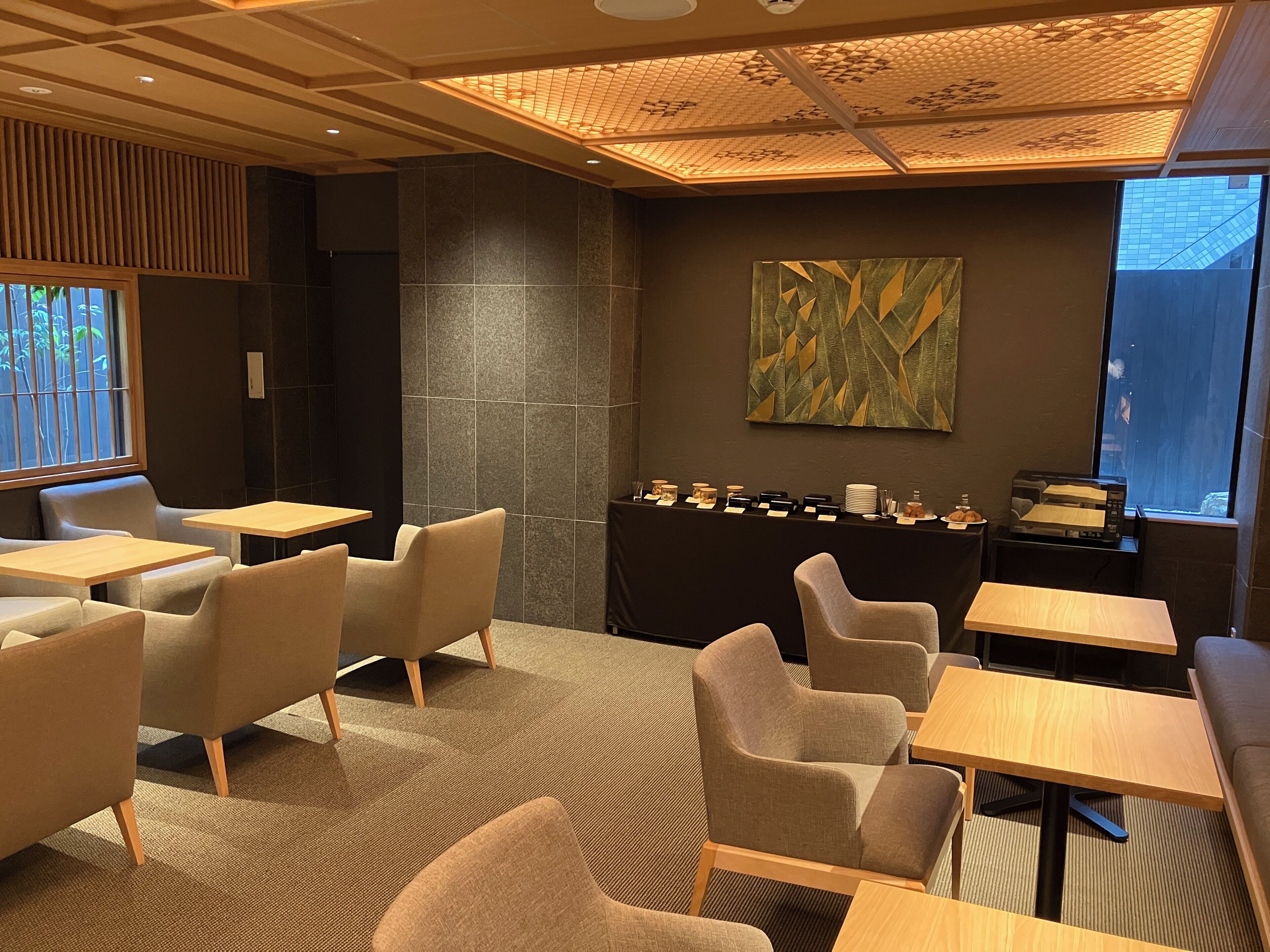 A modern interior with seating, a counter with items, and a large window.