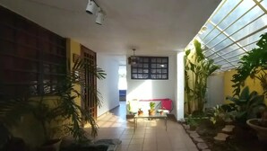 A hallway with tiled flooring, potted plants, a staircase, and a glass ceiling. - San Juan, Garden suite w/private POOL, outdoor kitchen/BBQ & peaceful (San Juan)