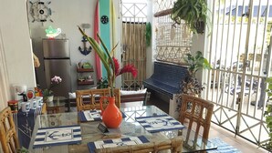 A dining area with a glass table, wicker chairs, and a decorative plant centerpiece. - San Juan, Garden suite w/private POOL, outdoor kitchen/BBQ & peaceful (San Juan)