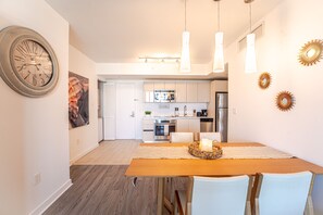 Enjoy meals in this dining area with a table for two, a decorative basket, and a large wall clock.