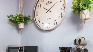 Une petite cuisine équipée d’un four à micro-ondes, d’une machine à café et d’une horloge murale.