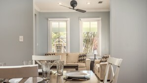 A dining area with a wooden table, white chairs, and a sofa. - Welcome to House on Hallett.  A historic home less than a mile from downtown (Mobile)