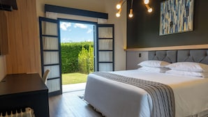 A bedroom with a large bed, a desk, and a view of the outdoors. - Pousada Terrazzo Bonjardim (Campos do Jordão)