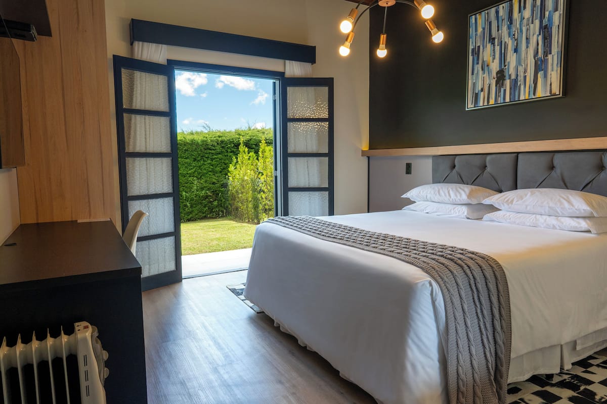 Une chambre avec un grand lit, un bureau et une vue sur l’extérieur.