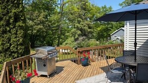 A wooden deck with a barbecue grill, outdoor table, chairs, and a potted plant. - Latitude Adjustment II - SIMPLY GORGEOUS WITH GREAT LOCATION CLOSE TO DOWNTOWN! (Frankfort)