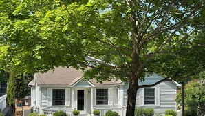 A two-story house with a front porch, a tree in front, and a well-maintained lawn. - Latitude Adjustment II - SIMPLY GORGEOUS WITH GREAT LOCATION CLOSE TO DOWNTOWN! (Frankfort)