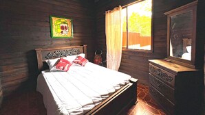A wooden room with a bed, a dresser, and a window with curtains. - Quinta El Zable (Zaragoza)
