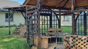Une structure rustique en bois, dotée d’un escalier en métal, d’un banc en bois et d’une pile de briques.
