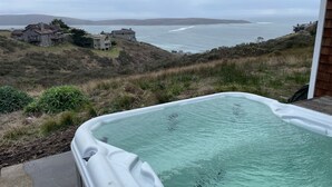 Ein Whirlpool mit Blick auf den Ozean und die Hügel.
