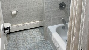 A bathroom with a shower, toilet, and a painting of a cow on the wall. - Two Bedroom Private Apt near NYC! (West New York)