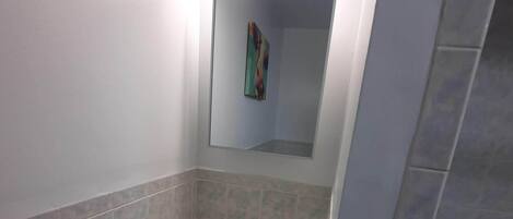 Un baño con lavamanos, espejo y lámpara.