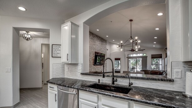 A modern kitchen with white cabinetry, a black granite countertop, and a built-in sink. - Walking distance to Scottsdale sports complex, Barrett Jackson, and Phoenix Open (Scottsdale)