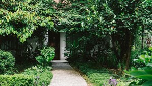 Un chemin menant à un bâtiment dont la porte est marquée du numéro « 110 ».