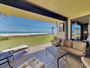 Une terrasse avec vue sur la plage, un canapé, une table et des chaises.