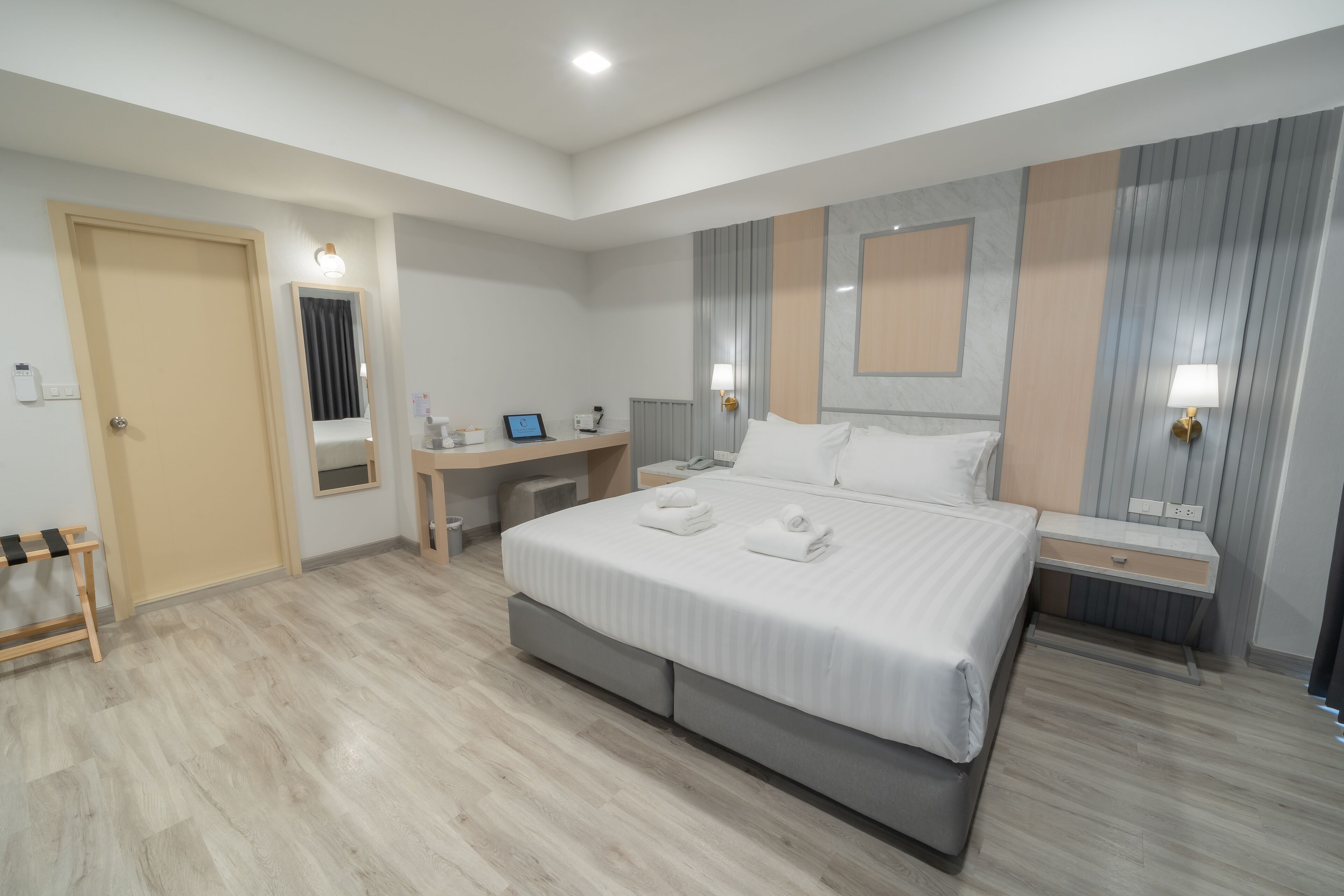 Una habitación de hotel moderna con una cama grande, un escritorio y una silla.