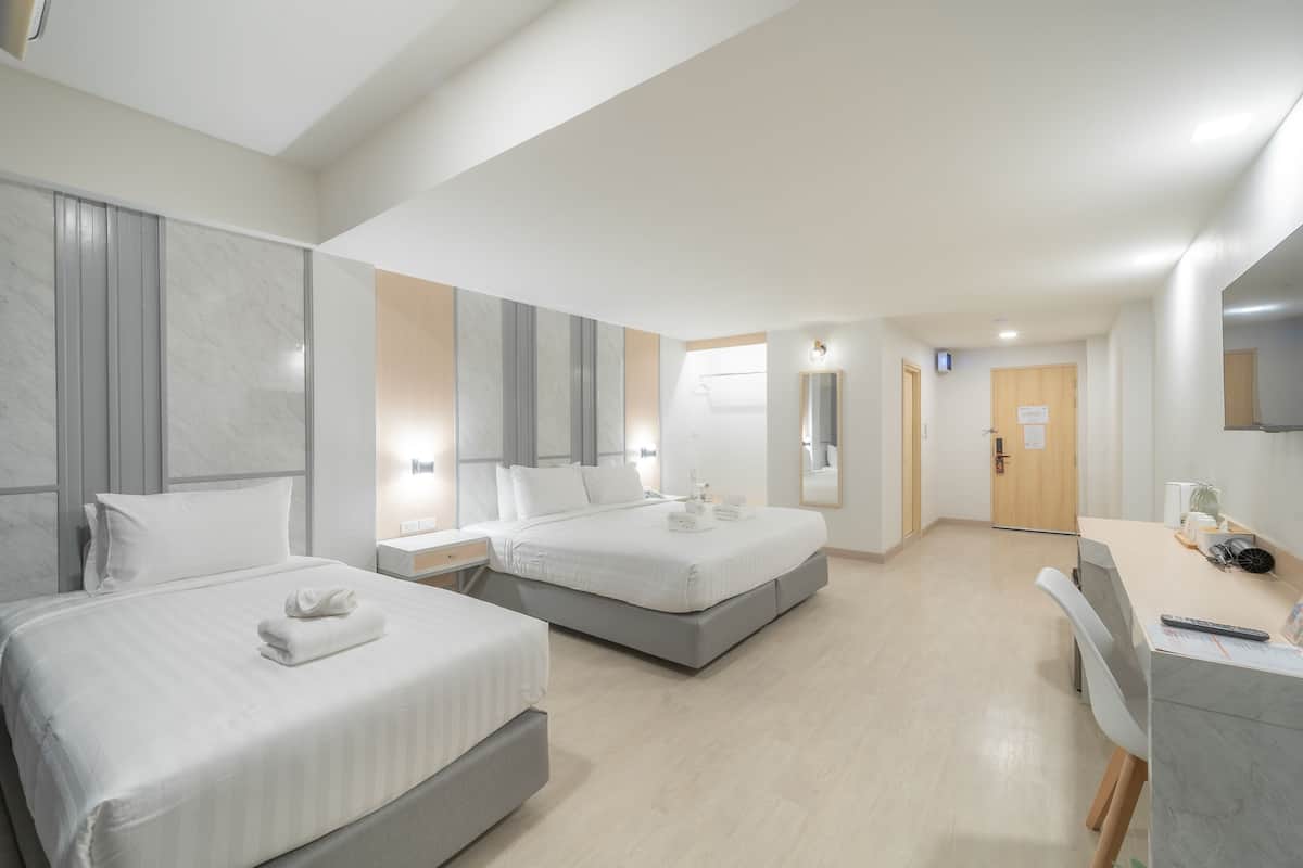 Une chambre d’hôtel moderne avec deux lits, un bureau et un miroir.