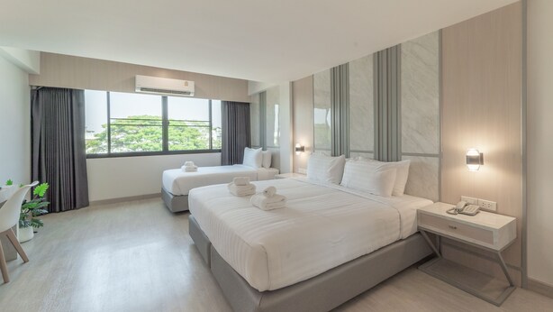 A modern hotel room with two beds, a desk, and a view of greenery outside. - The Space Hotel Lampang (Lampang)