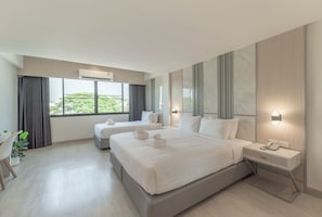 A modern hotel room with two beds, a desk, and a view of greenery outside. - The Space Hotel Lampang (Lampang)