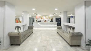 A hotel reception area with a modern design, featuring a reception desk, seating area, and a clean, tiled floor. - The Space Hotel Lampang (Lampang)