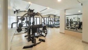 A gym with various exercise machines, mirrors, and a light-colored floor. - The Space Hotel Lampang (Lampang)