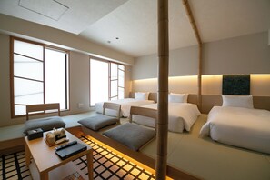 Une chambre d’hôtel avec deux lits, un bureau avec une télécommande et une fenêtre donnant sur un beau paysage.