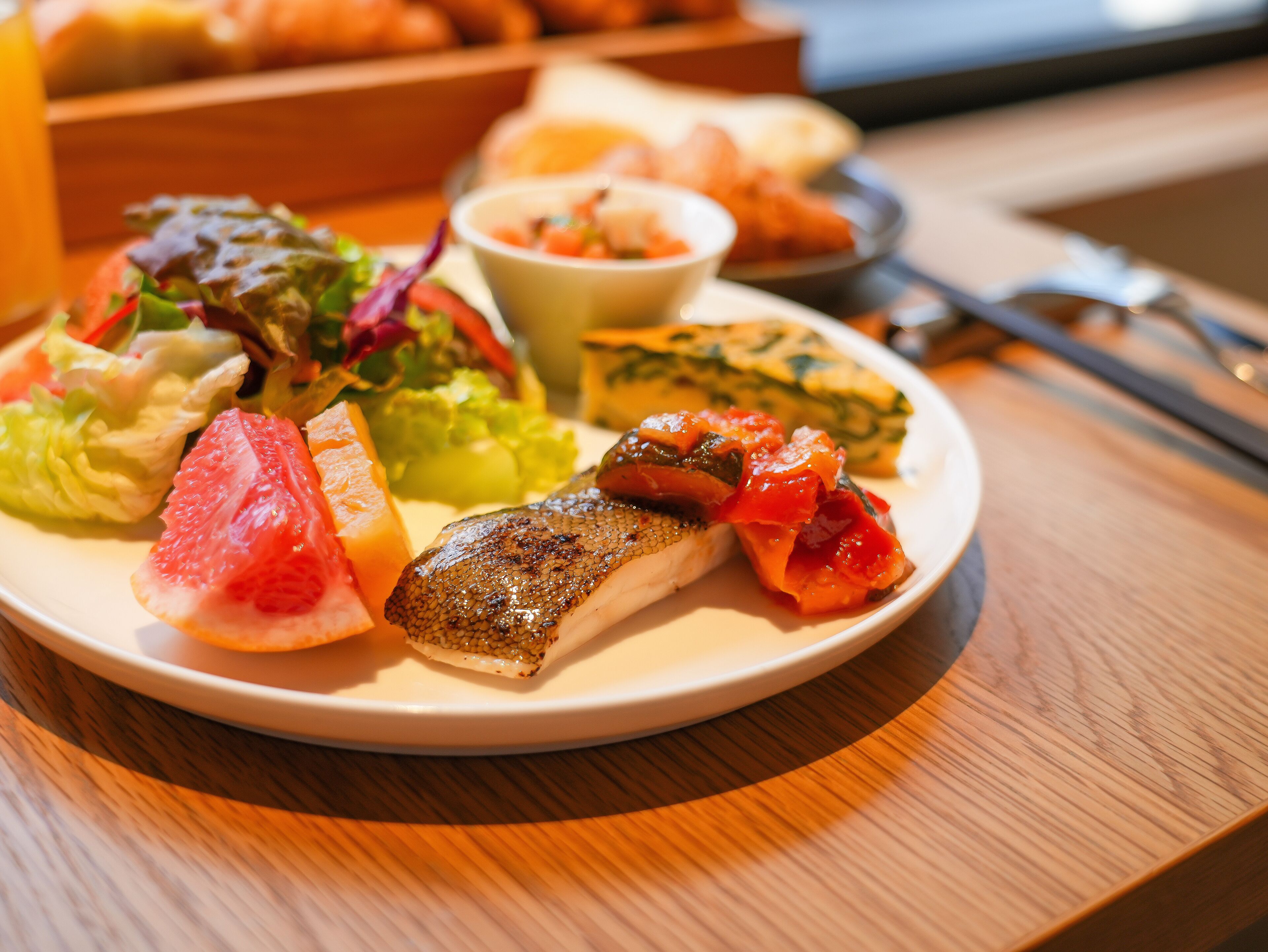 A plate of food including fish, vegetables, and a salad.