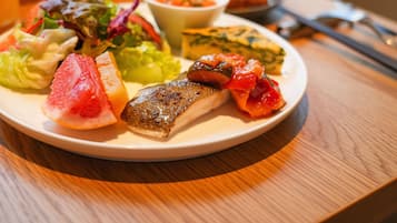 A plate of food including fish, vegetables, and a salad.