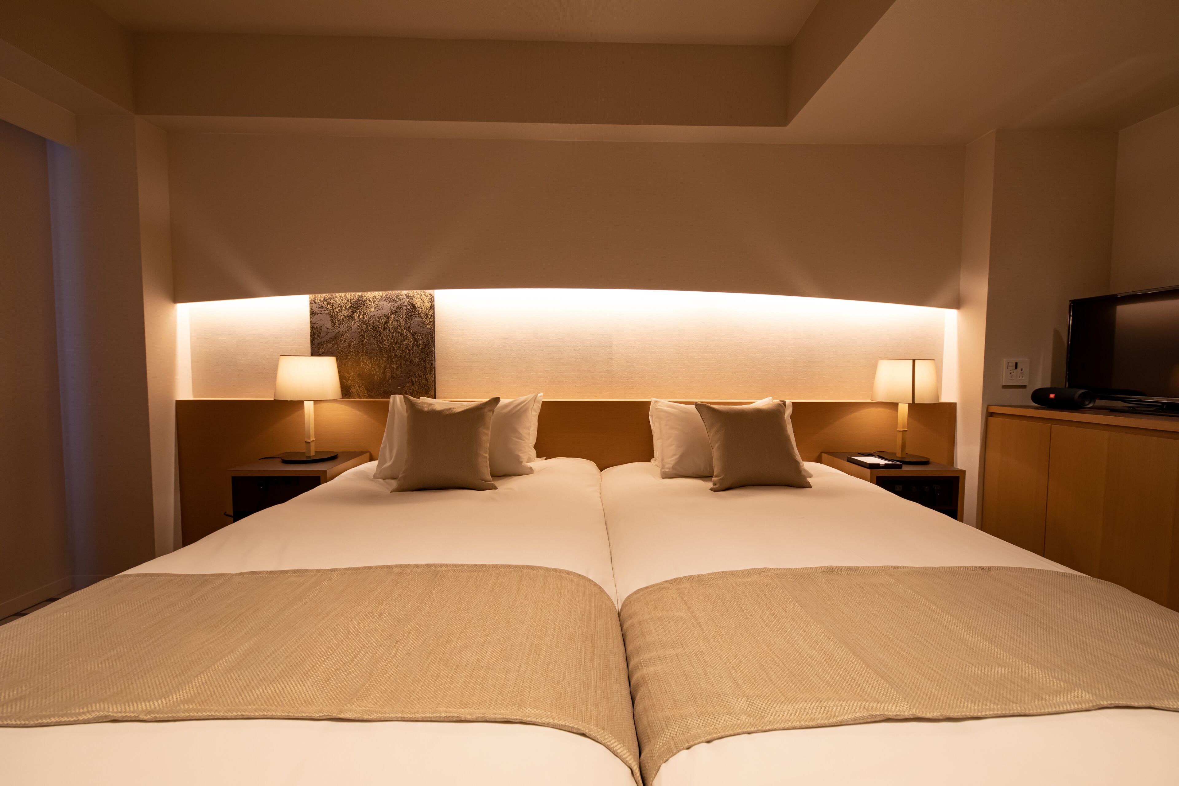A double bed with two nightstands, each with a lamp, in a hotel room.