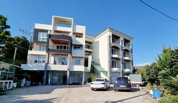 A multi-story building with a modern architectural design, featuring balconies and large windows. - Today Seogwipo (Seogwipo)