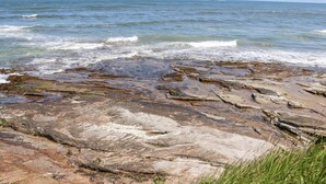 Une côte rocheuse où les vagues s’écrasent contre les rochers.