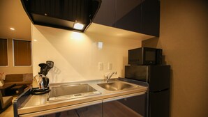 Une cuisine moderne équipée d’un évier en acier inoxydable, d’un four à micro-ondes et d’un réfrigérateur.