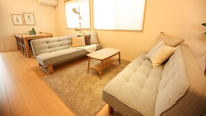 Un salon comprenant un canapé, une table basse et une table à manger avec des chaises.
