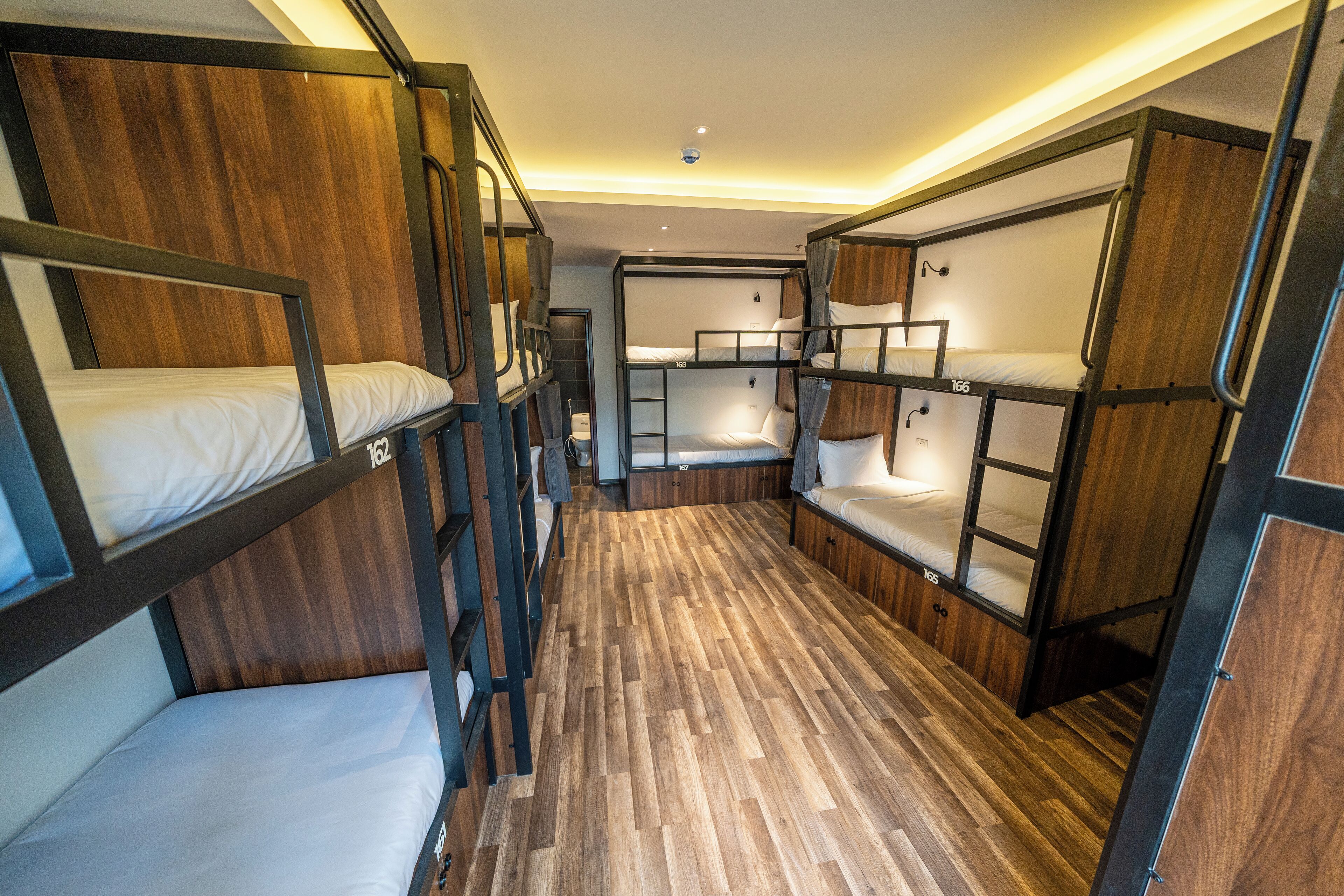 A compact, bunk-style room with wooden flooring and built-in bunk beds.