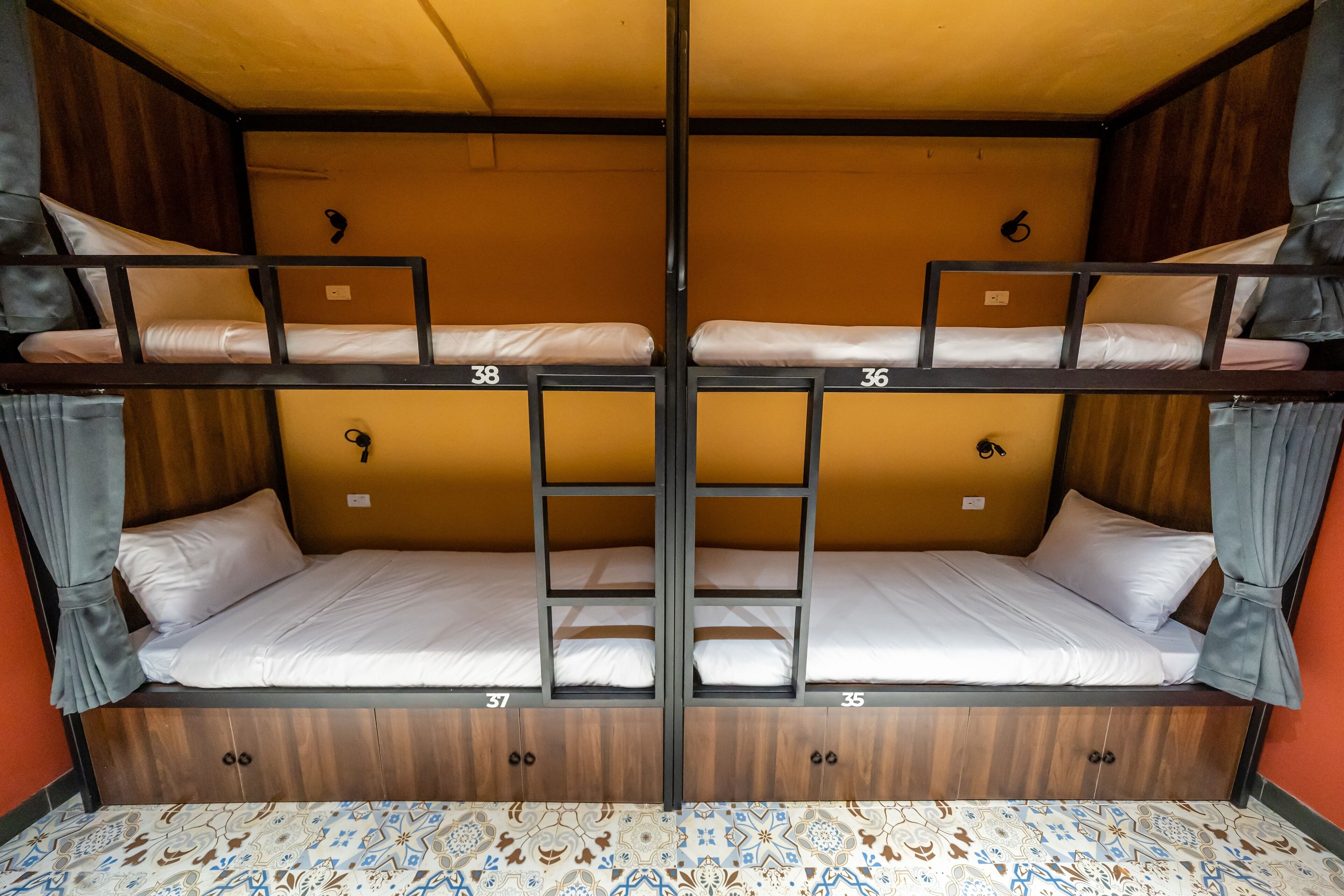 Une chambre avec des lits superposés, portant les numéros 35, 36, 37 et 38.