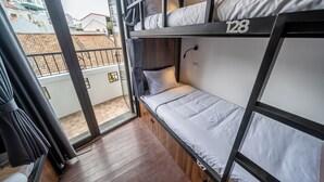 A bunk bed room with a balcony view, wooden flooring, and a window with curtains. - Mad Monkey Hanoi - Hostel (Hanoi)