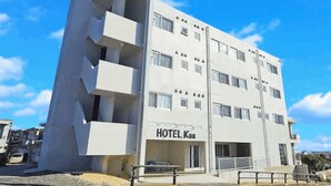 A modern hotel with a flat facade, multiple balconies, and a sign reading "HOTEL Ku". - HOTEL Kuu (Miyakojima)