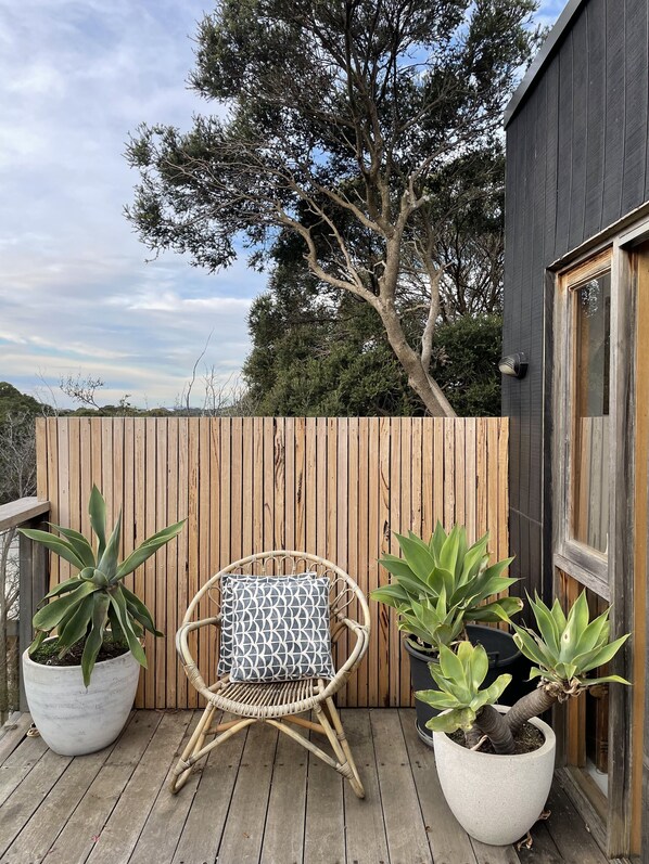 Relax on the deck with a wicker chair and lush greenery.
