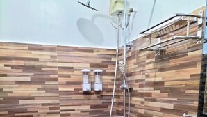 A modern bathroom with a wooden wall design, a shower with a handheld showerhead, and a white toilet. - Rapid Rise Hotel (Angeles City)