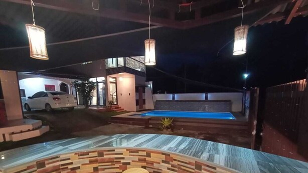A pool area with a curved seating area and a white car parked nearby. - Your Private Resort with Pool - A's Place! (Valencia)