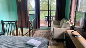 A room with a bed, a sofa, a desk, and a view of a balcony with outdoor furniture. - Your Private Resort with Pool - A's Place! (Valencia)