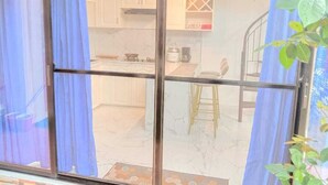 A kitchen with white cabinets, a marble countertop, and a stool. - Your Private Resort with Pool - A's Place! (Valencia)