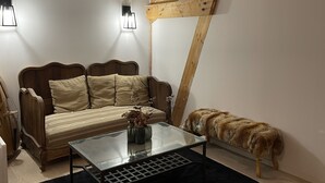 Ein gemütliches Zimmer mit einem Holzbett, einem Glastisch mit Blumen und einem Hund, der sich an der Wand ausruht.