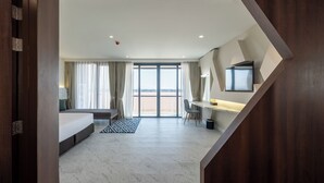 A modern hotel room with a large bed, a desk, a chair, and a television. - VELA Dhi Nakhon Phanom (Nakhon Phanom)