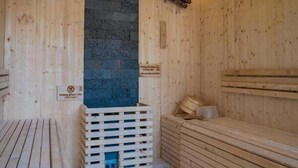 A sauna with wooden walls and benches, a central pillar, and a wooden floor. - 86 Homestay Phan Thiet (Phu Thuy)