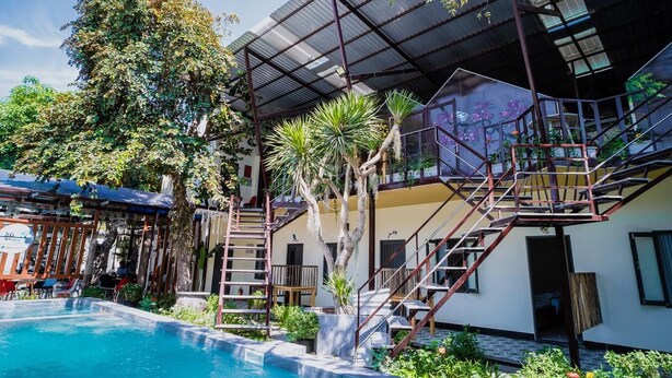 A poolside view of a building with a covered outdoor area, a staircase, and a pool. - 86 Homestay Phan Thiet (Phu Thuy)