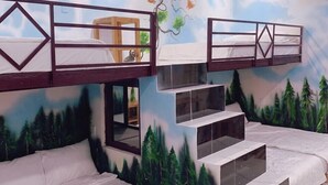 A room with bunk beds, a window, and a mural of a forest and sky. - 86 Homestay Phan Thiet (Phu Thuy)
