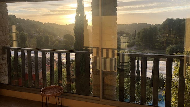 A balcony with a view of a sunset over a valley, stone walls, and a wicker chair. - Lovely, sunny, very quiet apartment facing south in Sanary sur mer  (Sanary-sur-Mer)