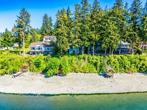 A coastal property with multiple houses, a beach, and a rocky shoreline.
